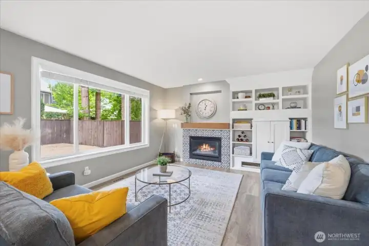 Welcoming family room with gas fireplace, built-in bookshelves and views of the fully fenced backyard!