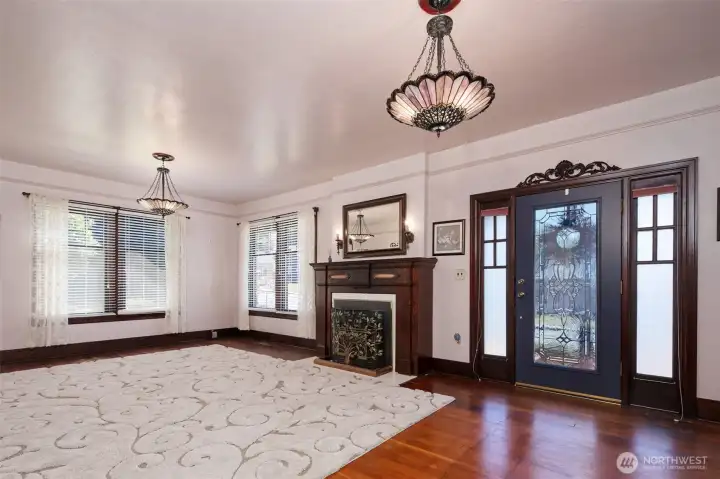 Primary living area with gas stove, stained glass light fixtues and beautiful main entry door.