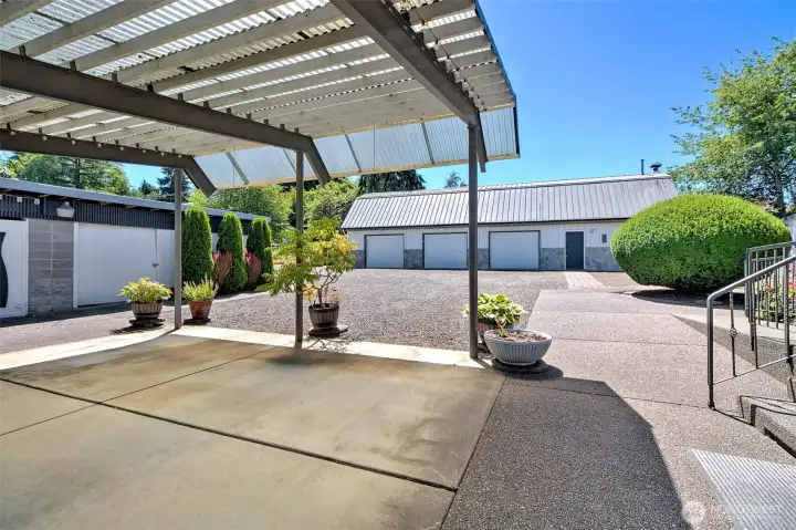 Patio with view of woodshed and workshop and fully fenced grounds.