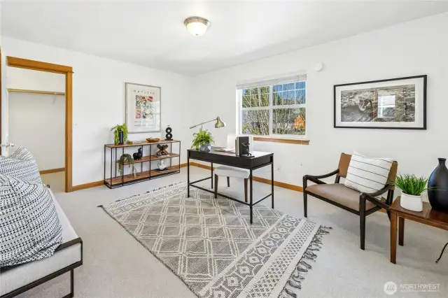 Bedroom two is currently styled as a home office, showcasing the room’s flexibility. Both upstairs guest rooms feature spacious closets on either side, providing ample storage and functionality.