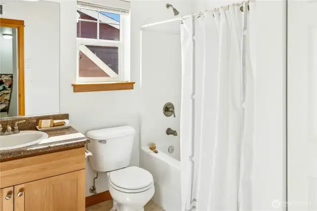 The upstairs full bath is filled with natural light, creating a bright and inviting atmosphere.