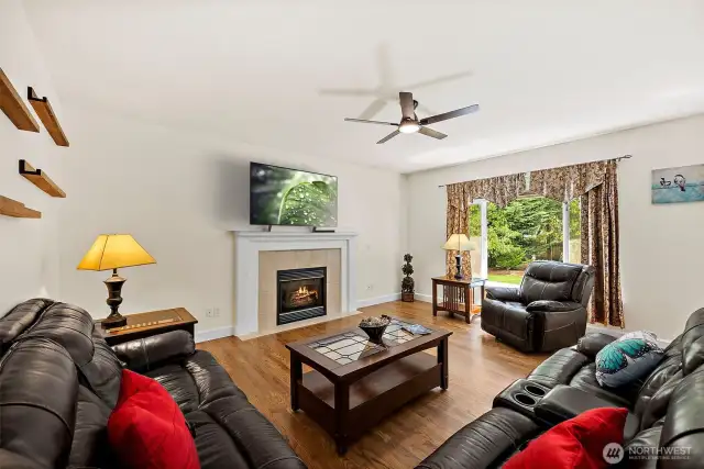 Expansive family room, with warm hues of the hardwood flooring and cozy furnishings that invite relaxation. (This room is partially virtually staged)