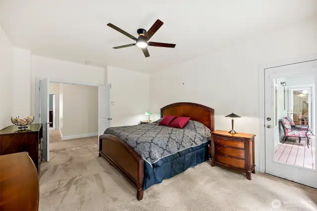 Spacious Primary bedroom with ensuite bath and large picture windows overlooking the backyard,