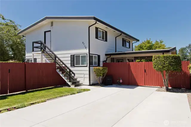 The Main Entrance is just beyond the carport gate and covered patio entertainment space. Note the additional staircase leading to the upstairs if needed.