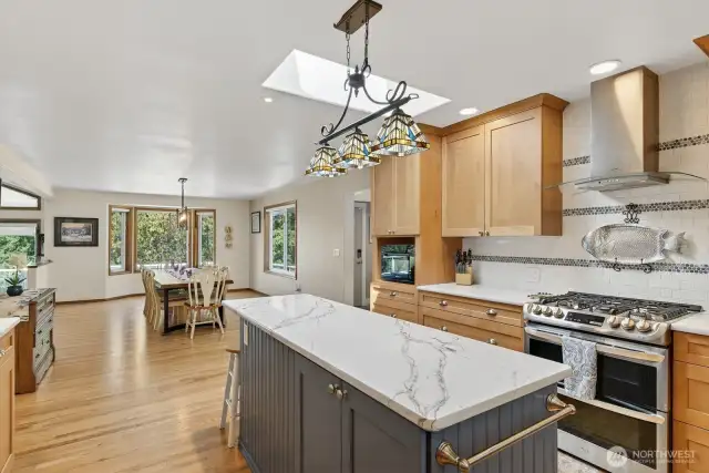 Beautiful kitchen with Island, quartz counters, stainless appliances, skylight and beautiful tile.