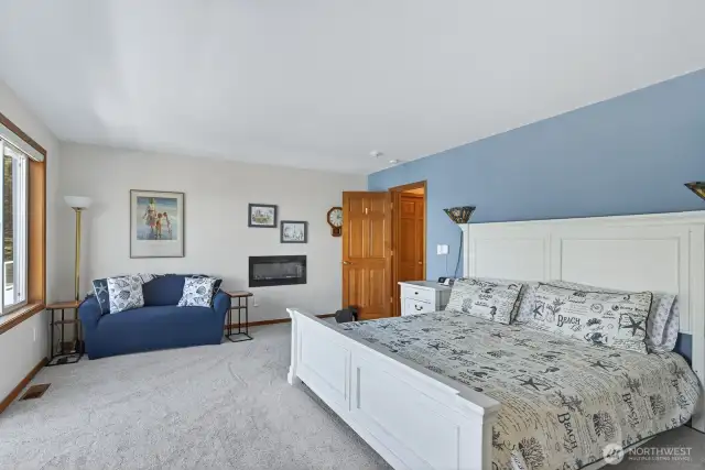 Primary main floor suite with electric fireplace in the wall.