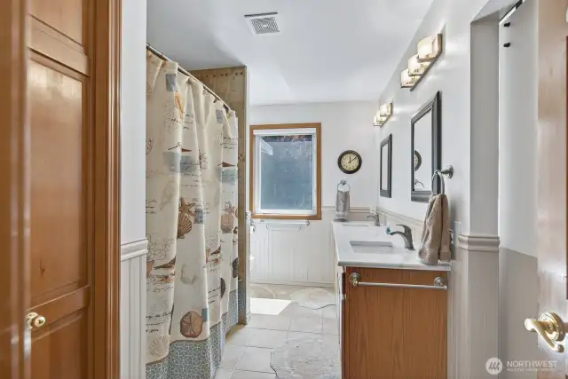 Upstairs full guest bath with tile floors and dual vanity. Linen closet too.