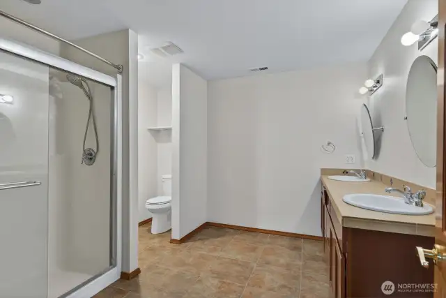 3/4 Bath of the second suite with tile floors and dual vanity.