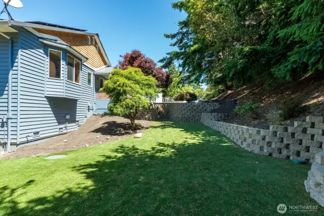 The yard is all artificial turf and beautiful retaining wall stone work.