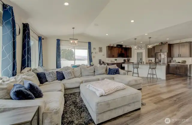 Step into an open floor plan with vaulted ceilings, recessed lighting, and oversized windows that fill the space with natural light.