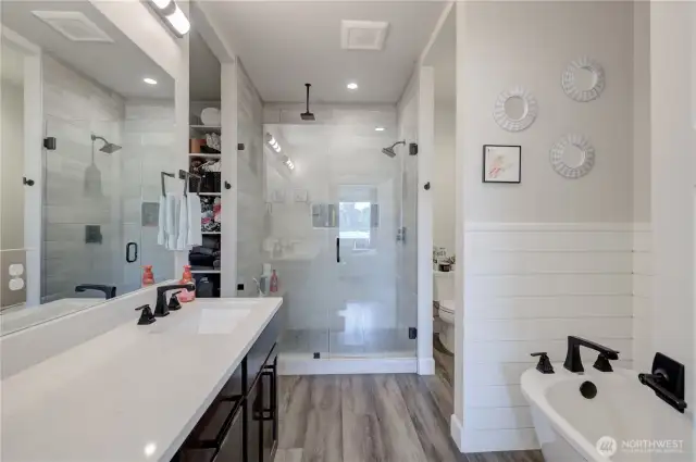 Walk in to the primary suite’s private, spa-like bath. Elegant five-piece bathroom boasting a double vanity, quartz countertops, tiled walk-in shower, and separate soaking tub.