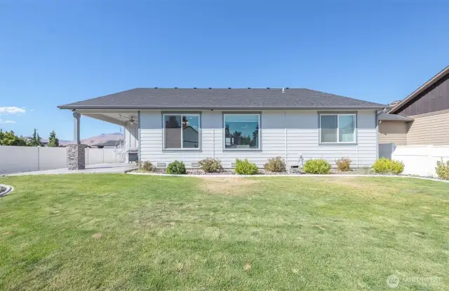 Fully fenced, flat backyard with ample grass space and simple landscaping for minimal upkeep