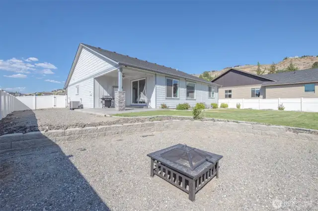Graveled area on the side of the house could be ideal for RV or boat parking. Firepit seating area set within a thoughtfully landscaped gravel space.