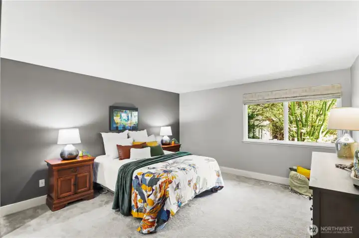 Expansive master bedroom with beautiful views of the manicured backyard and extensive closet space.