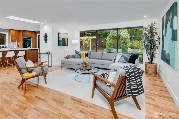 The beautiful white oak floors were refinished throughout the home (Swedish finish) in September 2025. The open living area flows effortlessly into the kitchen and dining area. Abundant natural light with new energy-efficient picture windows and remote-controlled skylights. (It is a beautiful PNW day, and the skylights are open- it starts to rain out of nowhere and you are not home- no worries... the skylights will close automatically if they sense rain!) The open floor plan flows into a stunning chef’s kitchen with sleek high-end appliances, expansive counters, and custom cabinetry—designed for both serious cooking and stylish entertaining.