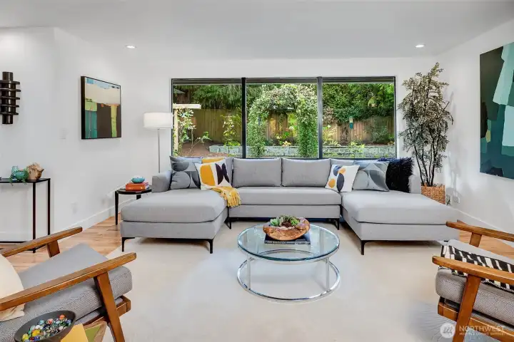 Large living room area with windows looking out to the level, fully fenced back yard.