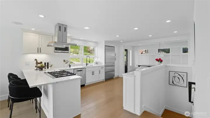 Gourmet kitchen features a peninsula with eating bar and gas range.