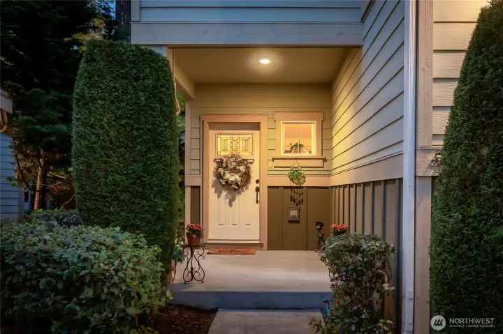Inviting entryway framed by mature landscaping and covered porch
