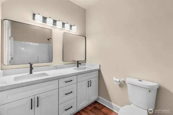 This bathroom conveniently serves bedrooms two and three, and is easily accessible for all guests. New vanity, quartz countertops, faucets, lighting and mirrors.