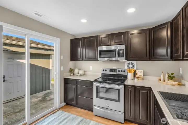 Large slider leads to front patio & detached garage with ample storage & an EV charger.