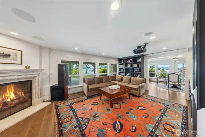 A state-of-the-art media room includes a motorized drop-down screen, projector, and wet bar for immersive cinematic experiences.