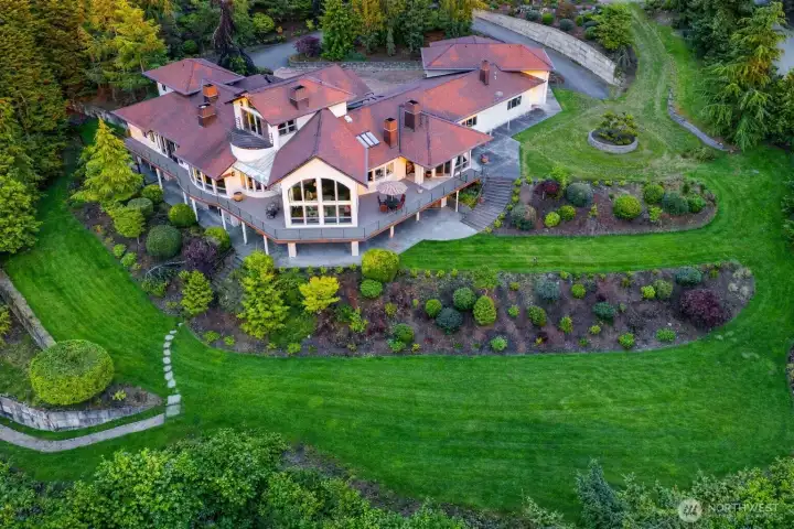 The residence is designed to embrace its setting, with expansive windows and tiered patios that connect seamlessly to the landscaped grounds.