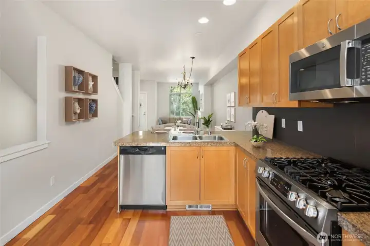 Chef kitchen boasts newer stainless steel gas range, microwave, and refrigerator all since 2025.