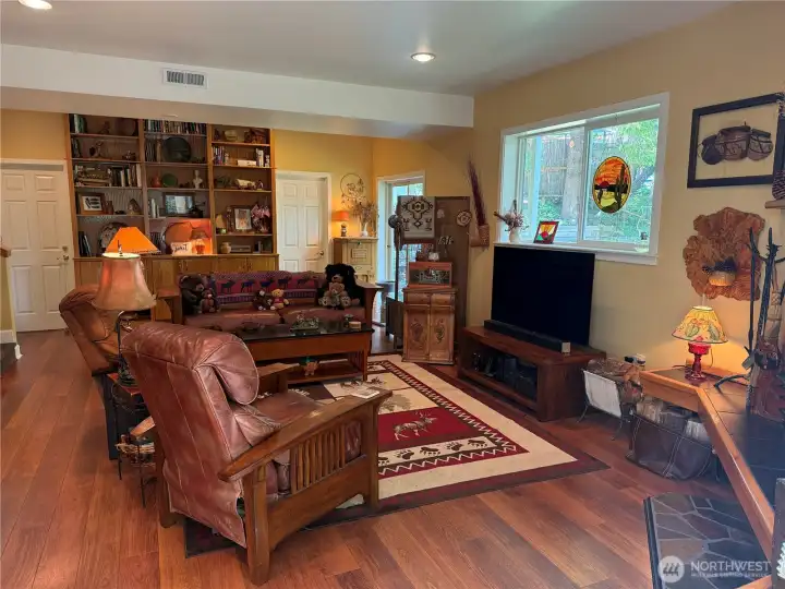 From the Sunroom enter into the Family room. Sliding glass door to the backyard at the far end of room near built-in bookcase.