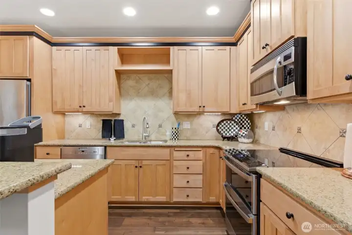 The kitchen is thoughtfully appointed with slab granite countertops, stainless steel appliances, New Double oven, a wine fridge, and under-mount lighting.