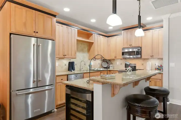 The kitchen is thoughtfully appointed with slab granite countertops, stainless steel appliances, New Double oven, a wine fridge, and under-mount lighting.