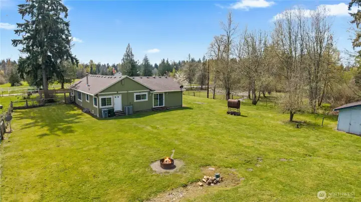 Rear exterior view highlighting the home’s privacy, open yard, and surrounding natural beauty—perfect for peaceful country living