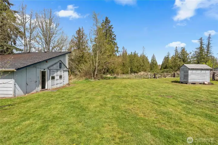 Open yard space with outbuildings, offering flexibility for storage, hobbies, or future improvements.