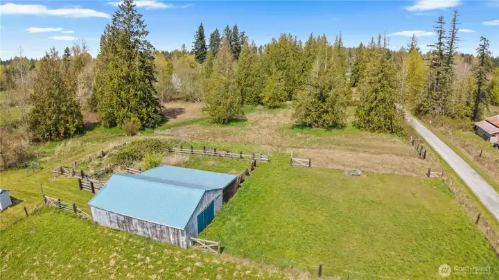 Aerial view highlighting full property layout including home, barn, shop, and surrounding acreage.