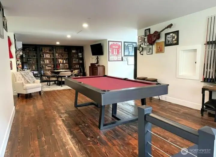 Large open loft and library where the modern cable railing continues up a second staircase to an open space perfect for entertaining.