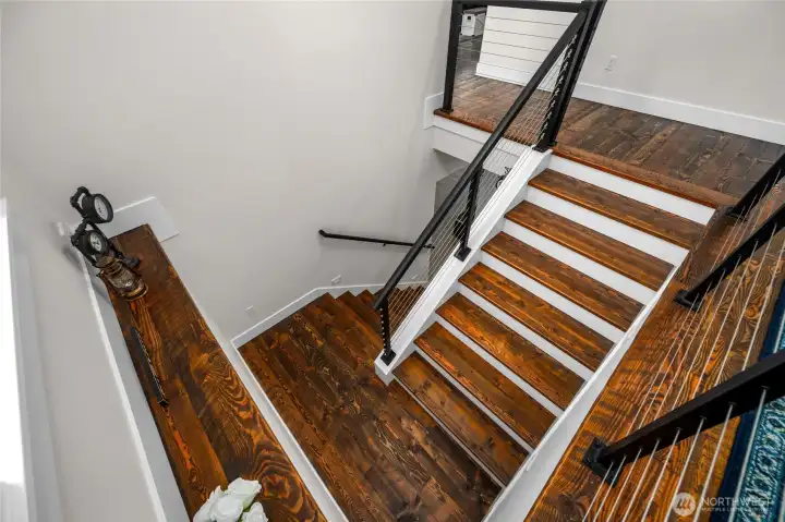 Custom hardwoods continue down to the basement. A secondary wood staircase exists near the garage up to the loft.