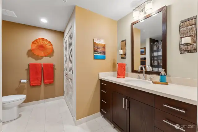 The bathroom features a marble counter and floors. Your laundry center with upgrades appliances is behind the louvered doors.