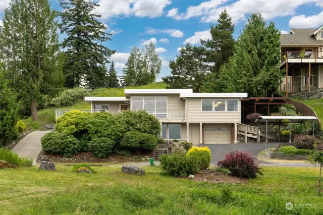 Welcome to this classic mid-century modern home with much of its original charm and character. The property continues up to that plateau behind the home and shop.
