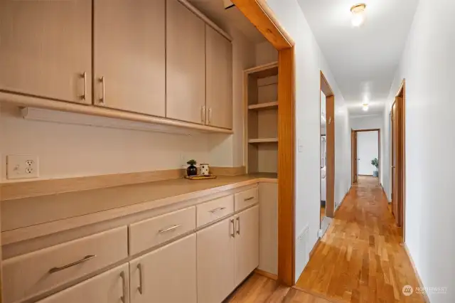 The built-in buffet is just in the hallway adjacent to the kitchen and across from the stairway to the basement.