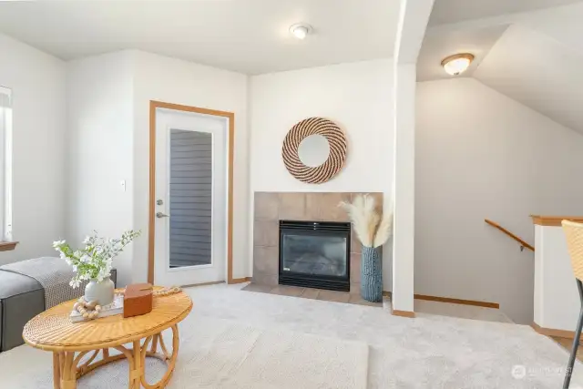 Cozy gas fireplace. Stairs lead down to entry & garage.