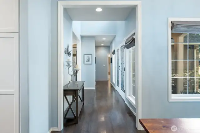 The colors and light from all angles provide such a beautifully calming effect in this interior.  This vantage point is from the formal dining room/home office looking past front door entrance and down hall to the Primary Bedroom Suite and Bedroom #2.