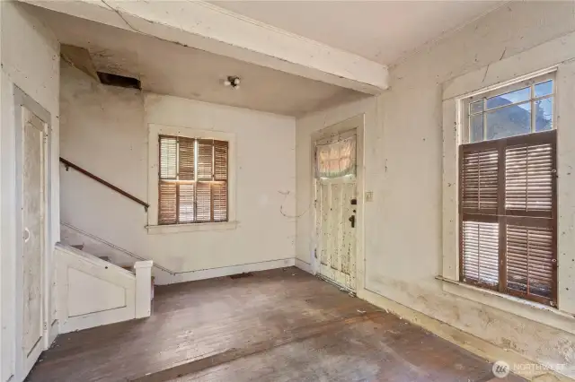 The front entry of the home, though not currently accessible, leads into a small foyer and to the living room.