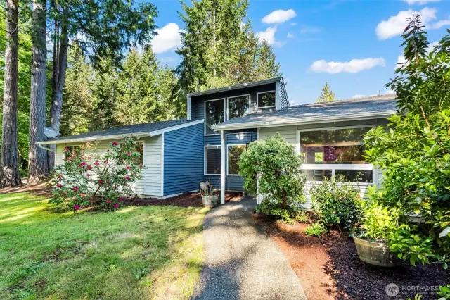 Western facing large front yard with multiple flowering trees.