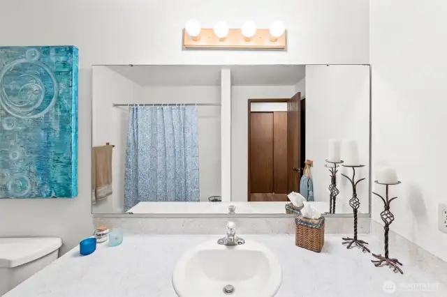 A full bathroom with tub & shower in the hallway.
