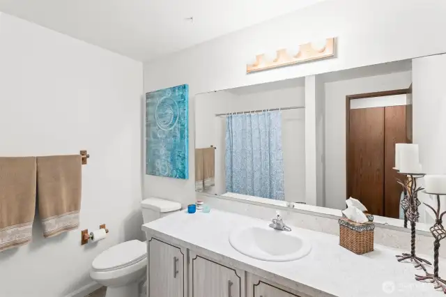 Newly surfaced countertops create a bright and clean guest bath.
