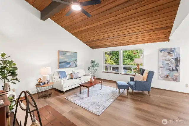 Enter the spacious living room with vaulted wood paneled ceiling.