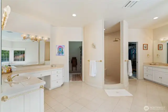 Primary Bathroom with dual vanities and extra large dual access walk-in closet with built-in organizers.