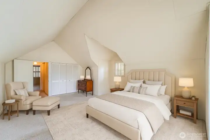 Primary bedroom with vaulted ceilings and private deck. Photo is virtually staged.
