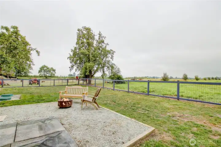 fenced back yard with views of expansive farm land