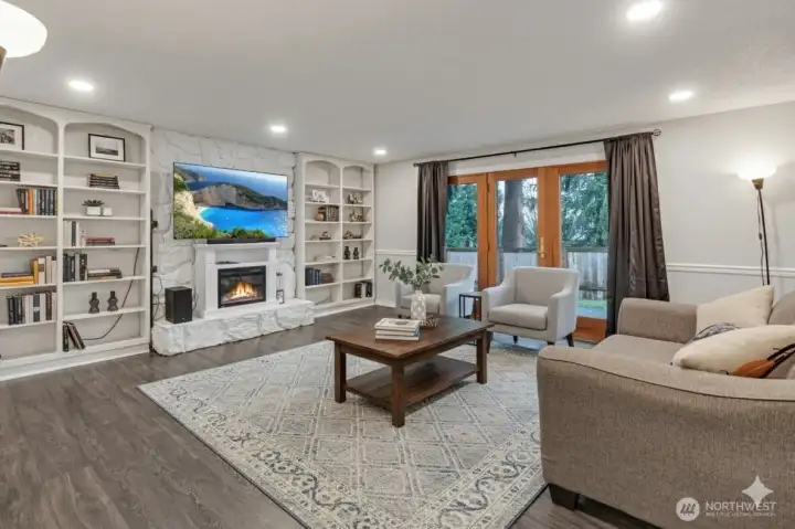 A delightful family room has a cozy fireplace banked by built-in shelves.