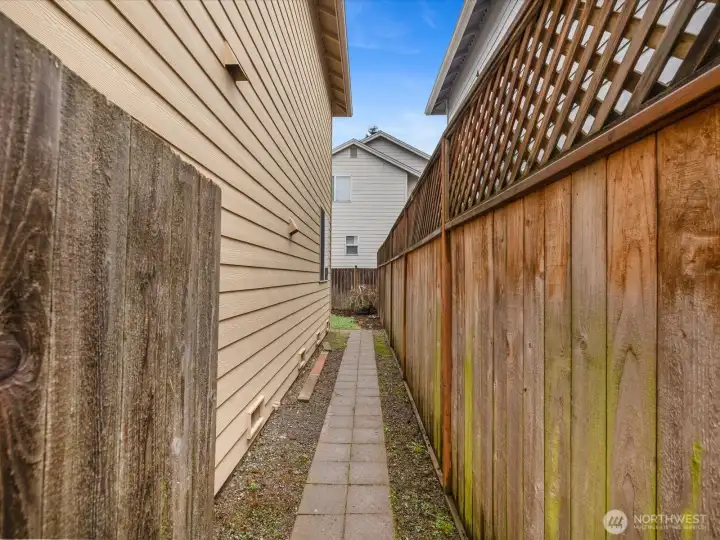 Private side entrance leads to a fully fenced backyard, offering both security and a peaceful outdoor retreat.